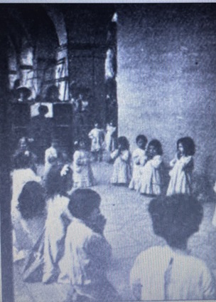 Children in a Montessori School in a circle singing, 1912.