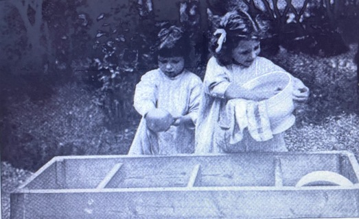 Two girls drying washed dishes in a Montessori School, 1912