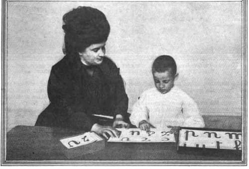 Maria Montessori working with an orphan on the sandpaper letters.