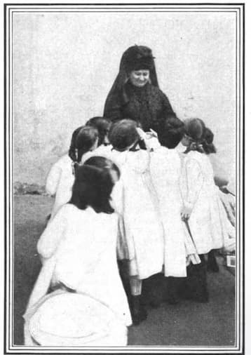 Maria Montessori surrounded by students