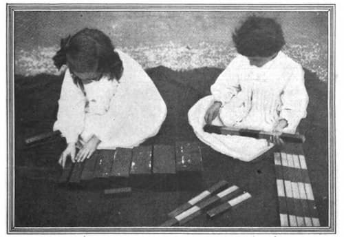 children working with the number rods and broad stairs in a Montessori classroom