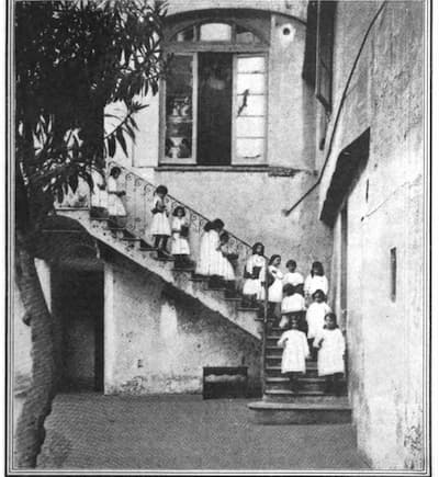 Children carrying materials down the stairs to the outdoor area
